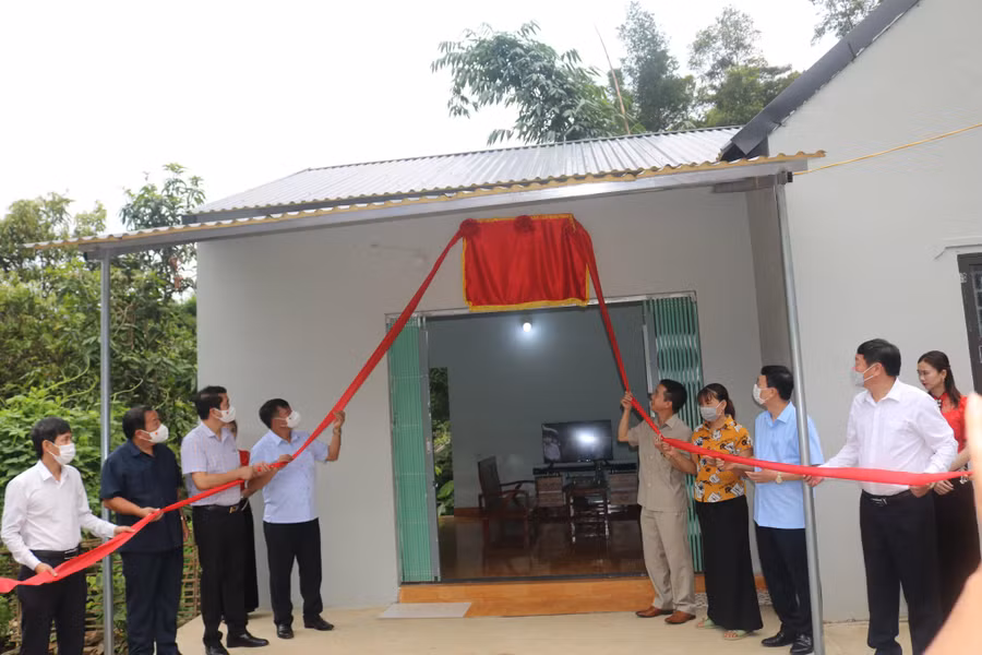 Các đại biểu thực hiện nghi thức gắn biển nhà ở cho hộ nghèo tại xã Hua Trai, huyện Mường La.