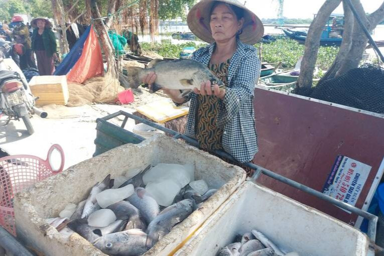 Bà Nguyễn Thị Lộc mang cá lên bán rẻ để vớt vát, giảm bớt thiệt hại.