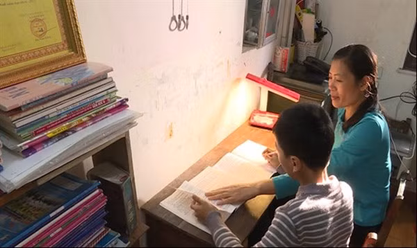 Mỗi tối, cô Thục đều dành thời gian để dạy Phúc học bài. Ảnh: TG