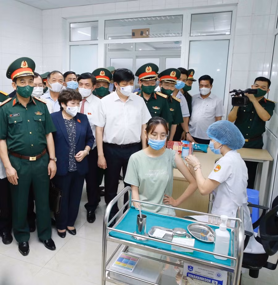 Bộ trưởng Bộ Y tế Nguyễn Thanh Long và Bộ trưởng Quốc phòng Phan Văn Giang hỏi thăm, động viên tình nguyện viên tiêm thử nghiệm vắc xin phòng COVID-19 Nano Covax. Ảnh: PV.