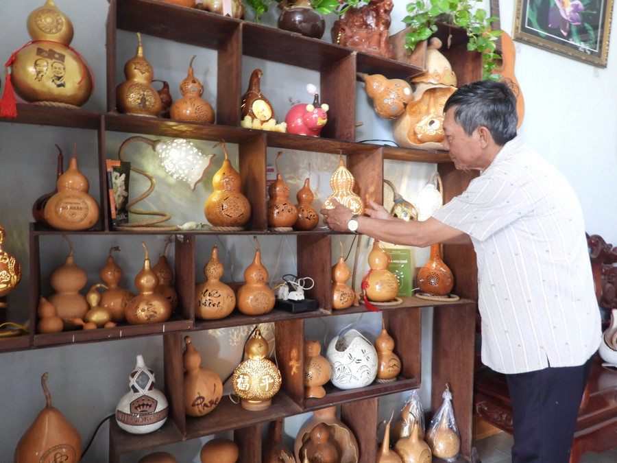 Ông Trần Văn Vinh bên các trái bầu hồ lô hoàn thiện trở thành vật phẩm phong thủy, trang trí.