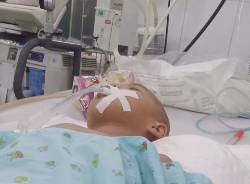 Cháu Anh Khoa nằm trên giường bệnh với chằng chịt ống dẫn, bơm tiêm và máy hỗ trợ khiến ai ai cũng phải xót xa thương cảm.