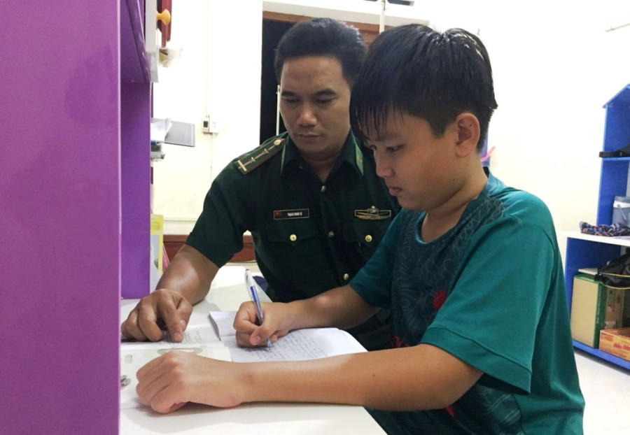 Từ khi về sống tại Đồn Biên phòng Mỹ Long, Duy luôn được những người bố nuôi kèm cặp trong học tập. Ảnh: Thạch Minh Từ khi về sống tại Đồn Biên phòng Mỹ Long, Duy luôn được những người bố nuôi kèm cặp trong học tập. Ảnh: Thạch Minh