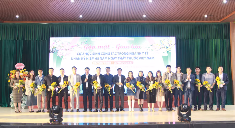 Ông Trần Hậu Tú – Chủ tịch Công đoàn ngành Giáo dục, lãnh đạo huyện Cẩm Xuyên tặng hoa và biểu trưng cho cựu học sinh công tác trong ngành Y tế (Ảnh: Hồ Tứ).