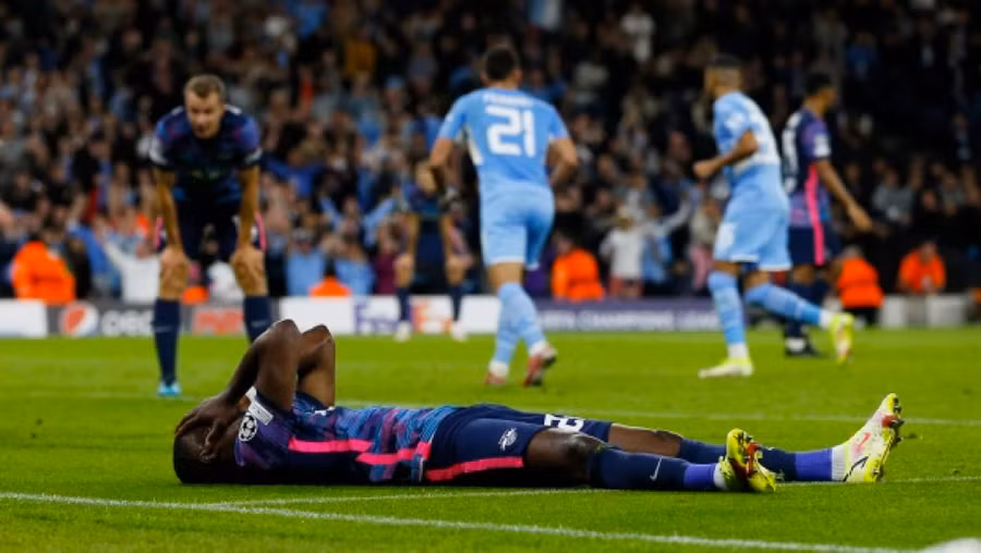 Mukiele nằm vật xuống sân ôm mặt sau khi phản lưới nhà.