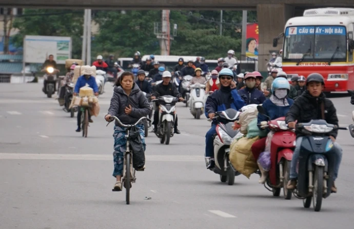 Người Hà Nội mặc áo mưa ngăn gió lạnh tê tái đầu đông