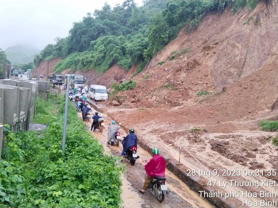 Các phương tiện di chuyển rất khó khăn trên đoạn đường sạt lở. Các phương tiện di chuyển rất khó khăn trên đoạn đường sạt lở.