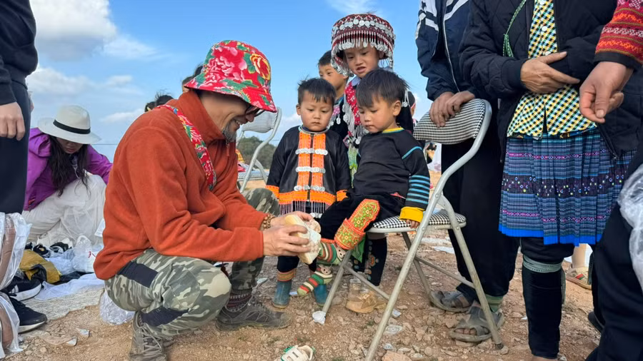 Thành viên CLB Biz36 tận tay xỏ giầy cho trẻ em bản Nậm Nghiệp.