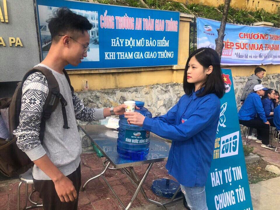 Tình nguyện viên phục vụ nước uống cho thí sinh trước cổng trường thi Tình nguyện viên phục vụ nước uống cho thí sinh trước cổng trường thi