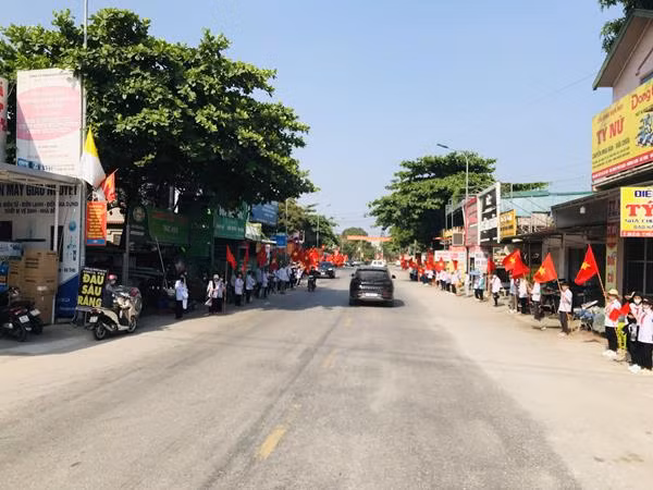 Hàng trăm học sinh đứng 2 bên đường, cầm cờ chào đón các anh hùng liệt sỹ. (Ảnh: Thế Tuấn). Hàng trăm học sinh đứng 2 bên đường, cầm cờ chào đón các anh hùng liệt sỹ. (Ảnh: Thế Tuấn).