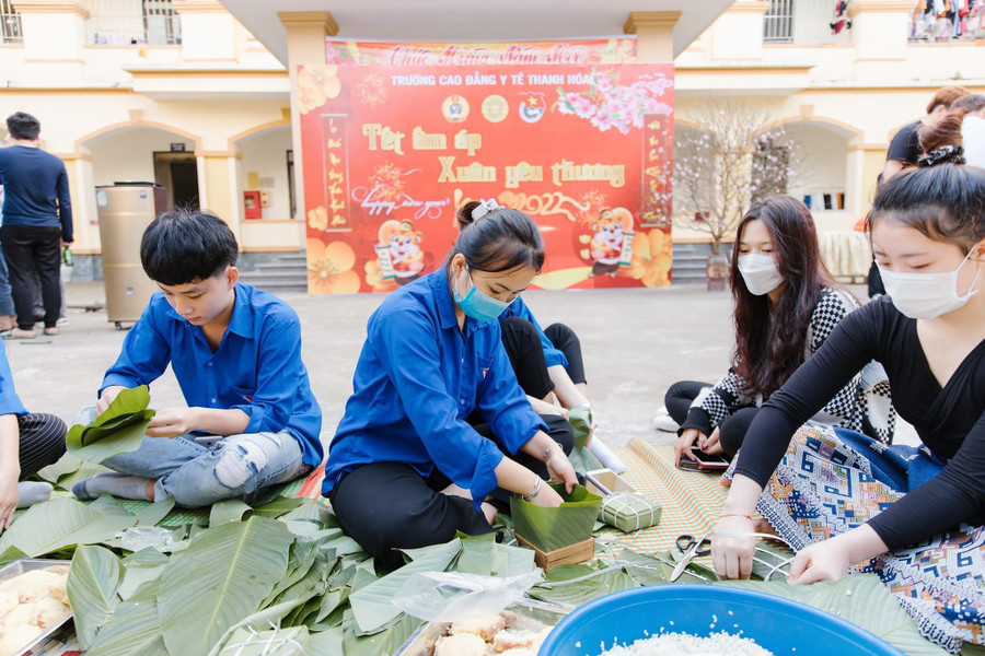 Lưu học sinh Lào và sinh viên Việt Nam tại Trường Cao đẳng Y tế Thanh Hóa cùng nhau gói bánh chưng. Ảnh: NTCC