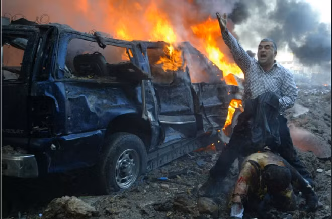 Một người đàn ông Lebanon hét to để tìm kiếm sự giúp đỡ sau khi thấy một người bị thương nặng tại khu vực gần nơi vụ đánh bom xe xảy ra tại Beirut. Vụ nổ đã khiến cựu Thủ tướng Lebanon Rafik al-Hariri và 8 người khác thiệt mạng. 