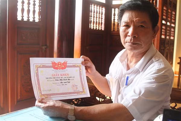 Ông Trần Hữu Phong nâng niu những tấm giấy khen của con cháu.