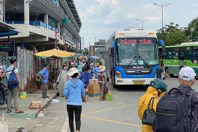 Một xe khách đón khách dưới chân cầu bộ hành trước Khu du lịch Suối Tiên.