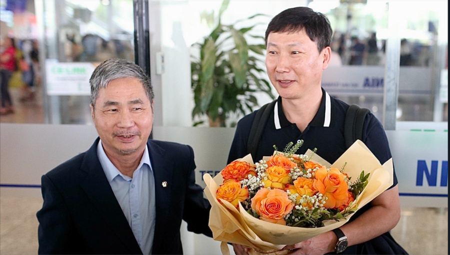 HLV Kim Sang-sik nhận bó hoa chúc mừng từ Tổng thư ký VFF Dương Nghiệp Khôi tại sân bay Nội Bài chiều 5/5.