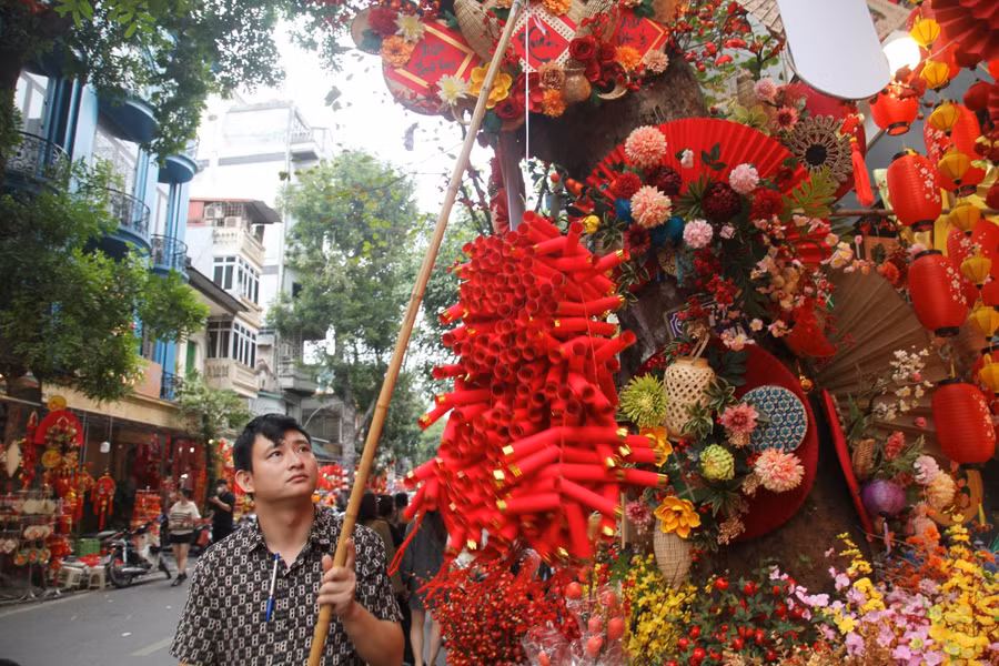 Phố Hàng Mã như được khoác một lớp áo mới, trở nên ấm cúng và ngập tràn sắc màu rực rỡ với các mặt hàng phổ biến như: Câu đối Tết, dây pháo, mâm ngũ quả, bánh chưng, dưa hấu…