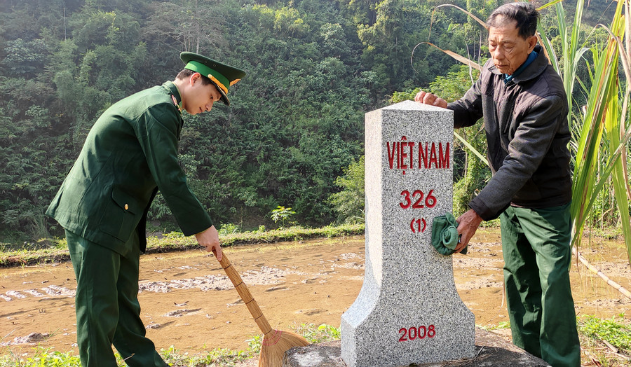 Cụ Lanh và chiến sĩ Đồn Biên phòng chăm sóc cột mốc.