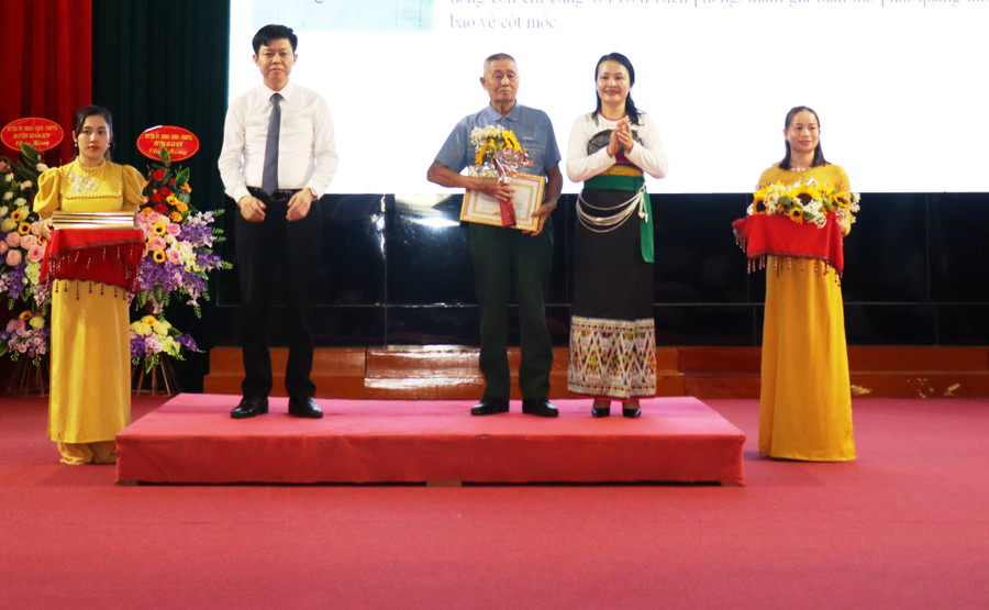 Cụ Vi Văn Hợi (giữa) được lãnh đạo huyện Quan Sơn vinh danh.