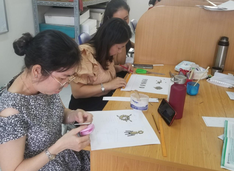 Giáo viên dùng thước, bút chì để định vị vị trí sẽ dán hình nổi vào trang phôi sách. Giáo viên dùng thước, bút chì để định vị vị trí sẽ dán hình nổi vào trang phôi sách.