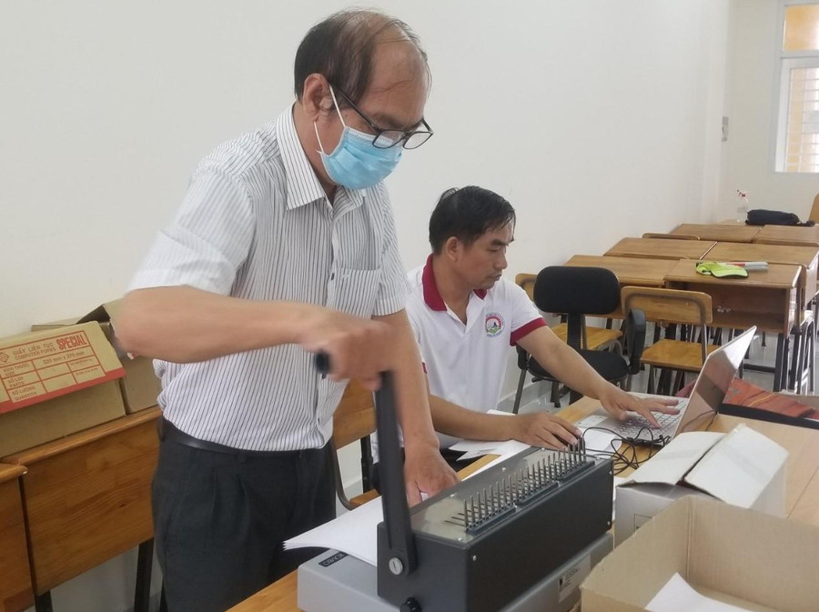 Các thầy giáo tiến hành đóng sách thành từng cuốn. Các thầy giáo tiến hành đóng sách thành từng cuốn.