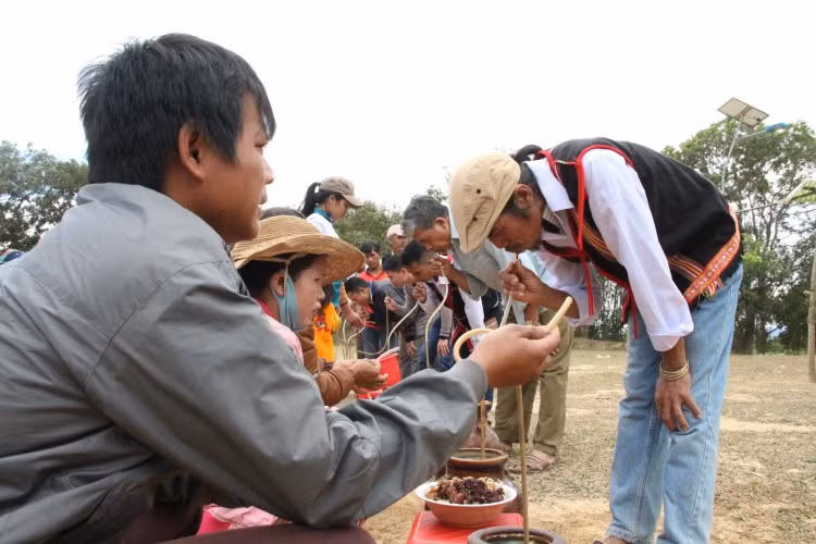 Già làng A Thui thưởng thức từng ghè rượu của người dân, sau đó cả làng nối đuôi nhau đi hết một vòng.