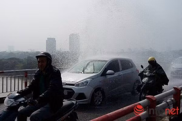 Vỡ đường ống nước, người dân mặc áo mưa đi qua cầu Chương Dương ảnh 1