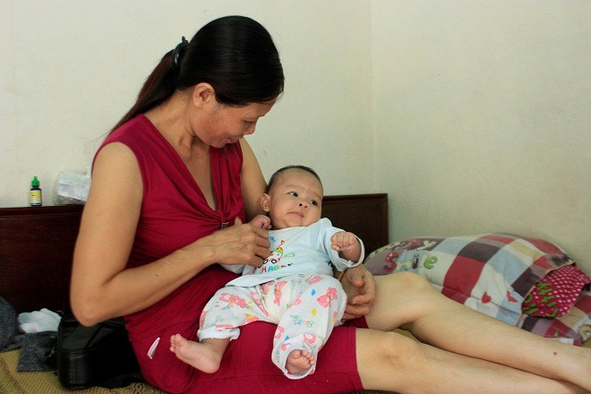 Bé gái 3 tháng tuổi trong vòng tay bà Mai. Ảnh: Phương Chi. Bé gái 3 tháng tuổi trong vòng tay bà Mai. Ảnh: Phương Chi