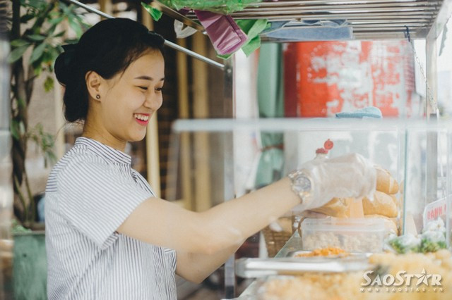 Bỏ việc công sở, hotgirl ra vỉa hè bán bánh mì trộn ảnh 11 Khách đi đường nhìn thấy xe bánh mì thường rất ngạc nhiên vì hiếm khi người ta được thấy hình ảnh một cô gái trẻ đẹp đứng bán bánh mì ngoài đường như thế này.