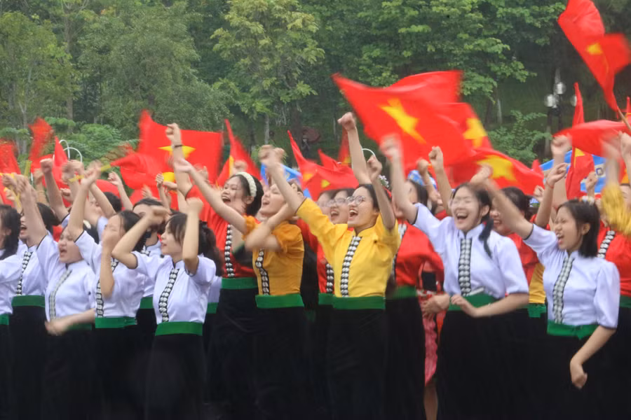 Học sinh Trường THPT Chuyên Sơn La mặc áo cóm và cầm cờ Tổ quốc reo hò, cổ vũ Anh Đức.