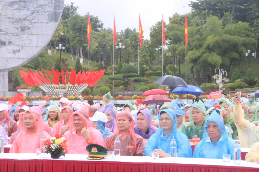 Các đại biểu mặc áo mưa dưới khán đài theo sát các hoạt động của cuộc thi Olympia.