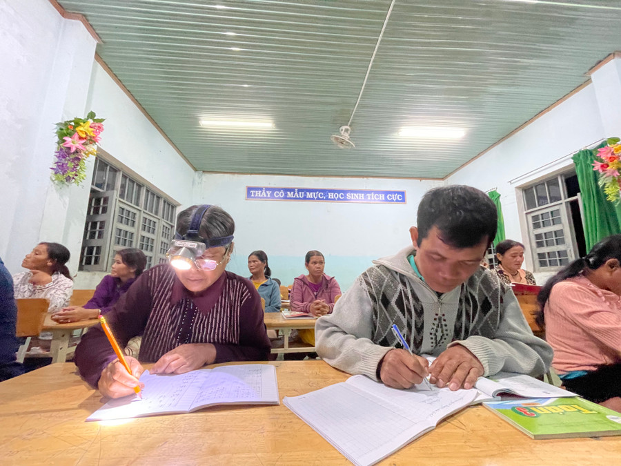 Vợ chồng bà Y Mơk rủ nhau đi học chữ. Ảnh: Dung Nguyễn