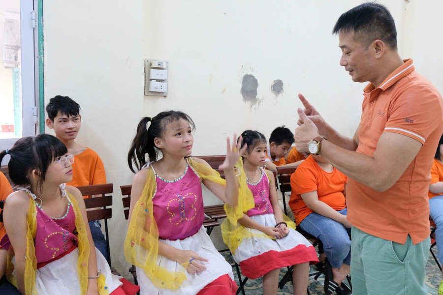 Thầy Sơn (ngoài cùng bên phải) trò chuyện với học trò bằng ngôn ngữ ký hiệu. Ảnh: TG Thầy Sơn (ngoài cùng bên phải) trò chuyện với học trò bằng ngôn ngữ ký hiệu. Ảnh: TG