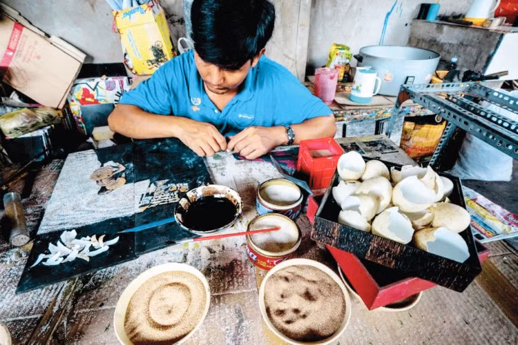 Nghệ nhân làng nghề sơn mài Tương Bình Hiệp đang thực hiện một công đoạn làm sản phẩm