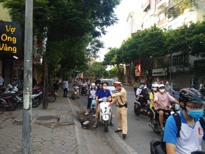 Lực lượng chức năng kiểm tra, nhắc nhở học sinh vi phạm Luật Giao thông đường bộ.