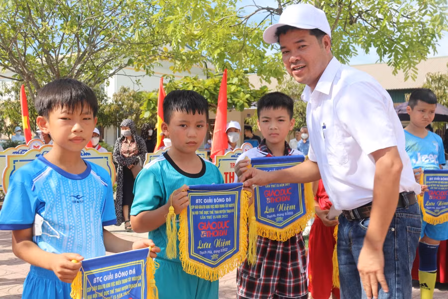 Ông Nguyễn Văn Dũng, Trưởng văn phòng đại diện Báo GD&amp;TĐ khu vực MT-TN trao cờ lưu niệm, khích lệ tinh thần thể thao, rèn luyện sức khỏe của các em học sinh.