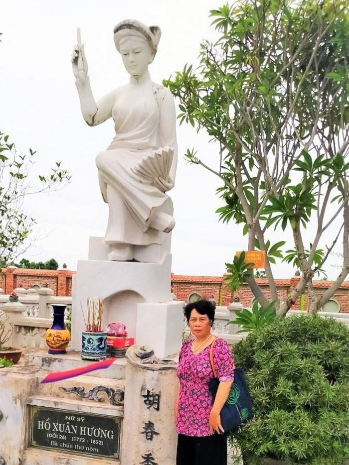 Nhà thơ Nghiêm Thị Hằng bên tượng nữ sĩ Hồ Xuân Hương. Ảnh: NVCC