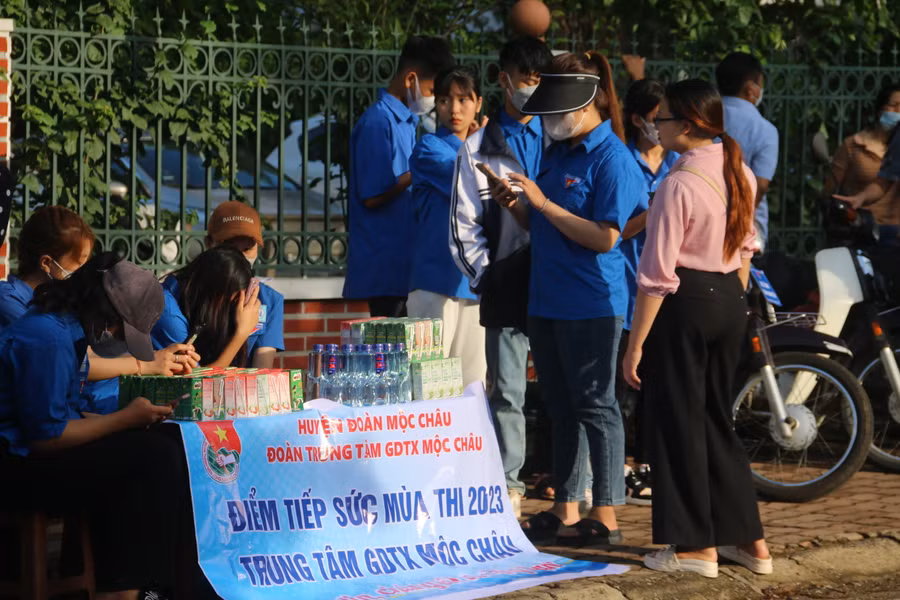 Các thanh niên tình nguyện huyện Mộc Châu đang hỗ trợ nước, sữa cho các thí sinh.