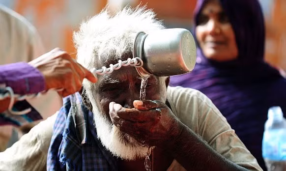 Cụ già uống tại một điểm công cộng tại thành phố Allahabad. Giới chức Ấn Độ yêu cầu các bệnh viện coi say nắng là trường hợp cấp cứu. Ảnh: Getty 1