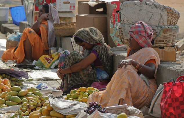Cô bán trái cây tranh thủ chợp mắt khi chờ khách ở thành phố Hyderabad, bang Andhra Pradesh. Người già, phụ nữ mang thai, trẻ em mẫn cảm với nắng nóng nhất. Chính quyền khuyến cáo người dân không nên ra đường vào thời điểm nắng gắt, tìm bóng râm để nghỉ ngơi. Ảnh: Daily Mail 1