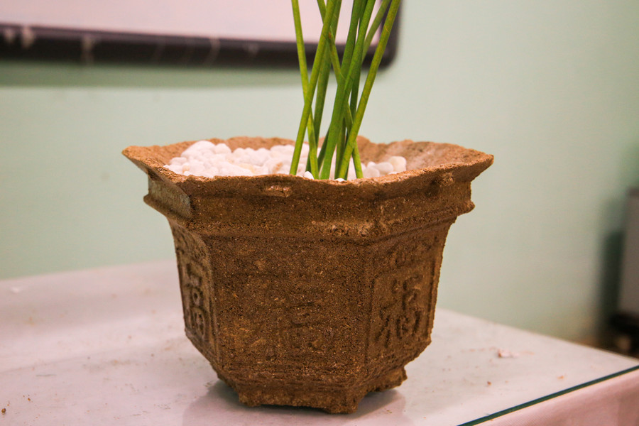 Chậu đựng cây cảnh được nhóm học sinh khắc chữ xung quanh. Chậu đựng cây cảnh được nhóm học sinh khắc chữ xung quanh.