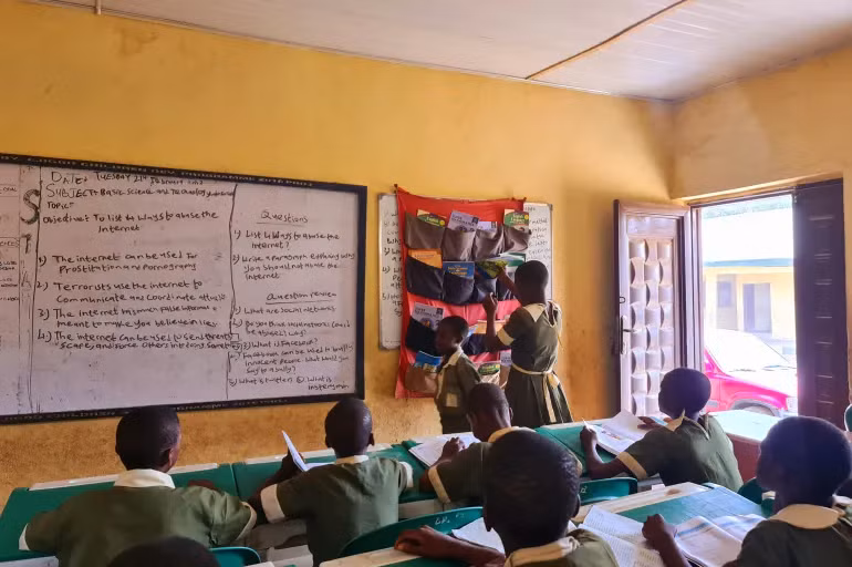 Một học sinh ở Ejigbo, Lagos chọn sách từ thư viện treo. Ảnh: Al Jazeera