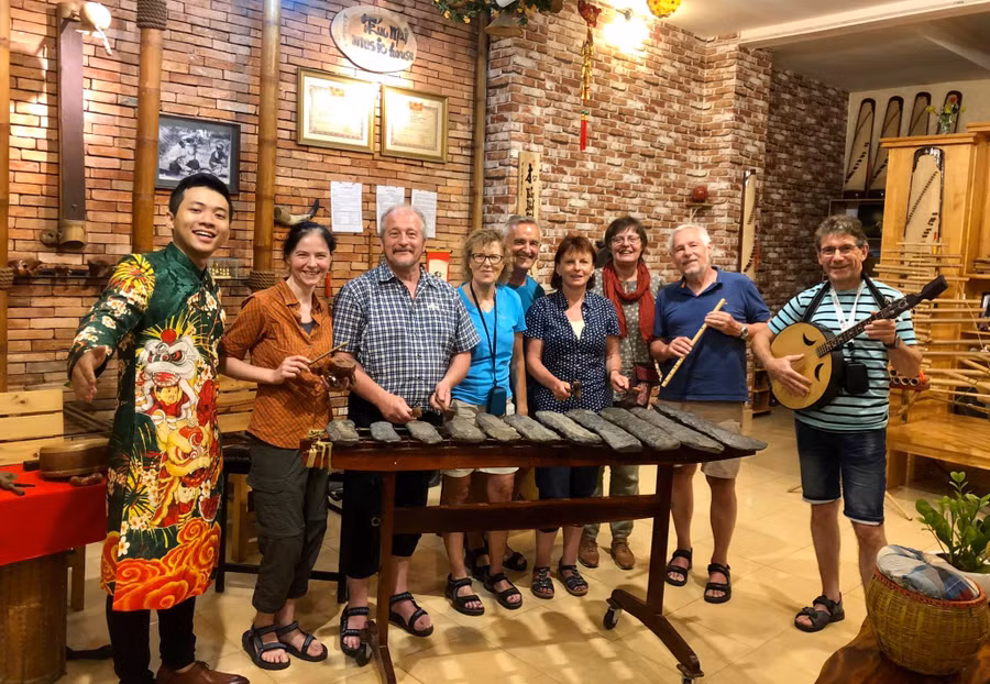 Nghệ sĩ Đinh Nhật Minh (bìa trái) với các du khách nước ngoài tại 'Trúc Mai House'. Ảnh: NVCC.