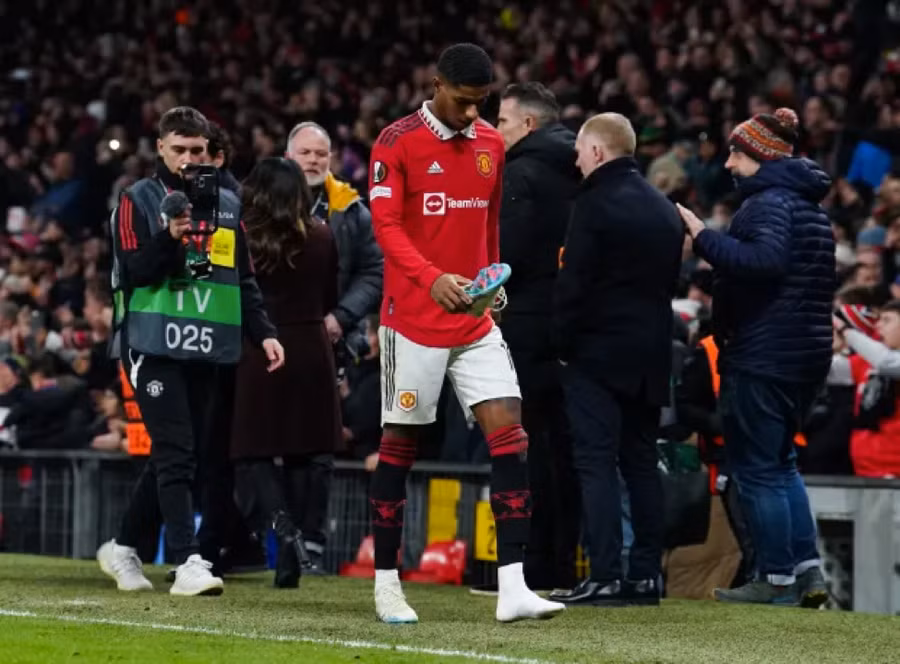 Rashford tháo giày khi lê bước xuống đường hầm