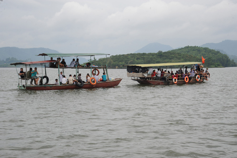 Du khách dạo chơi trên lòng hồ Cấm Sơn bằng thuyền máy