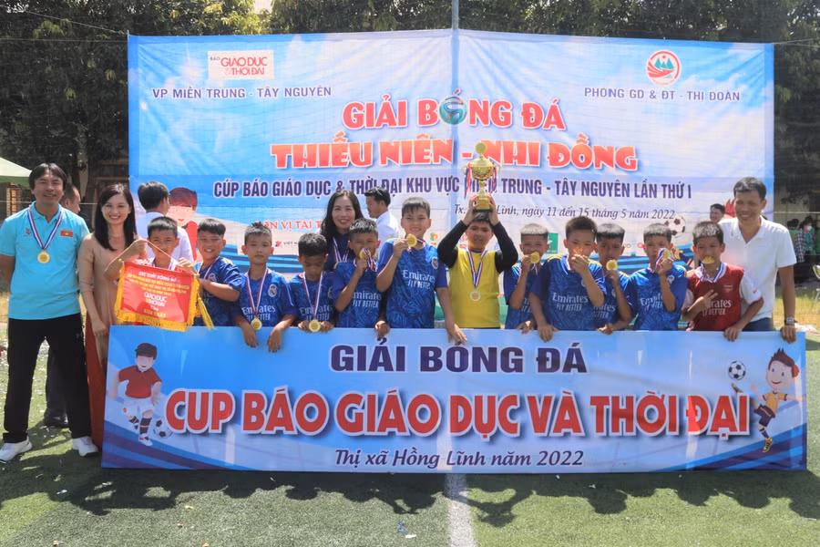 Các cầu thủ nhí cùng giáo viên nâng cup chiến thắng.