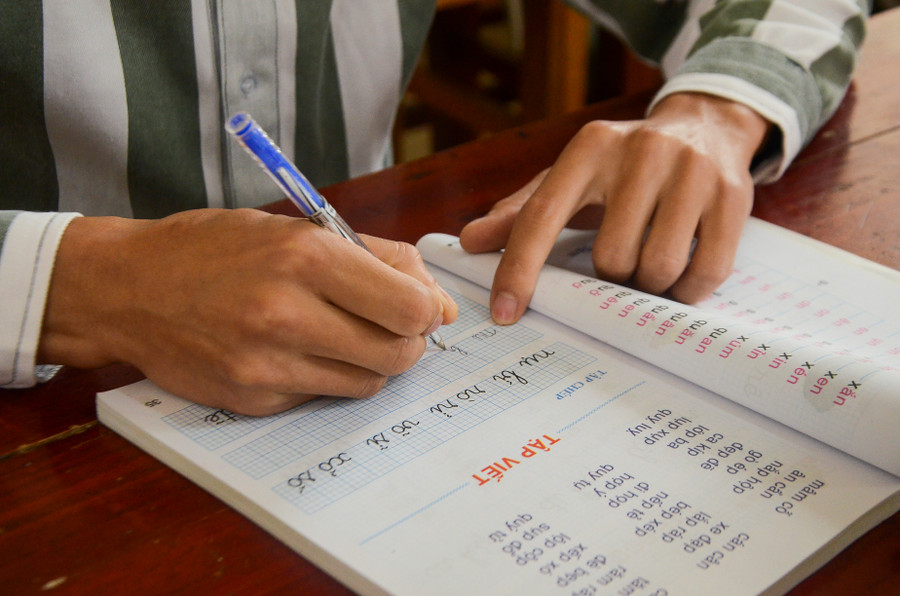 Phạm nhân nắn nót những nét chữ đầu tiên.
