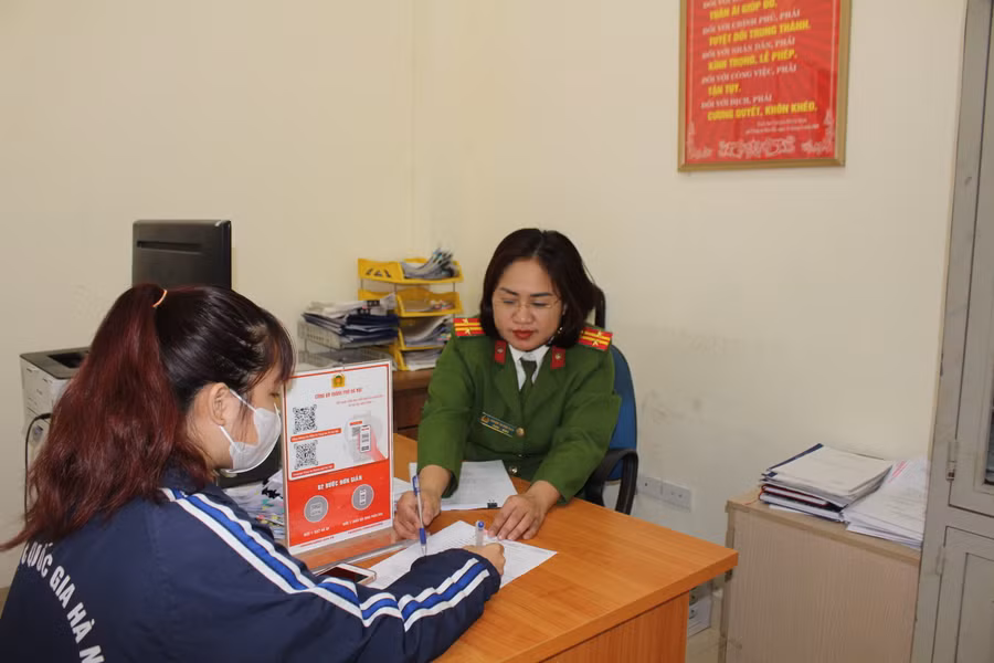 Sinh viên Nguyễn Kim Huệ được cán bộ Công an phường Đông Ngạc hướng dẫn các thủ tục hành chính.