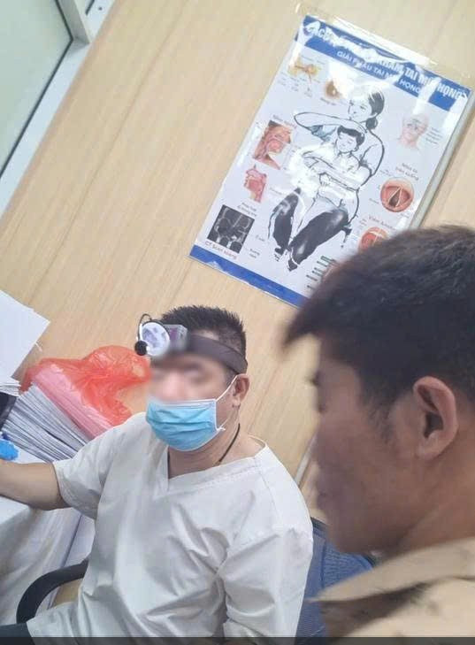 Người đàn ông (áo trắng) khám bệnh tai, mũi, họng không đeo biển tên - (Ảnh: cắt từ video). z6694106704011-d66d48a1a77e687eac88eddbadab2354.jpg