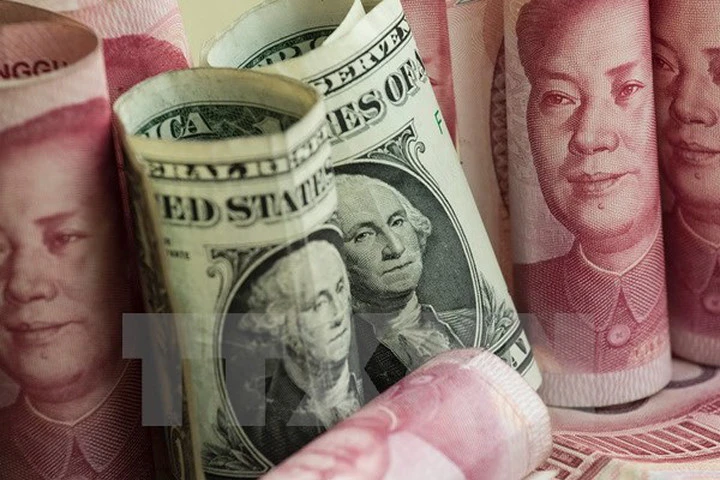 Tiền giấy mệnh giá 100 nhân dân tệ của Trung Quốc và đồng USD. Ảnh: AFP/TTXVN