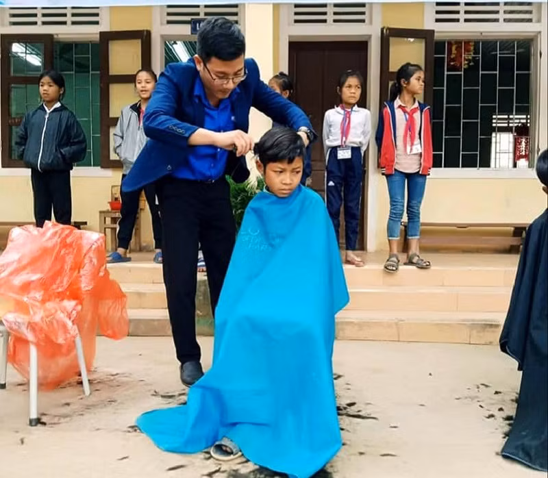 Thầy Trần Mạnh Hùng cắt tóc miễn phí cho trẻ em. Ảnh: NVCC